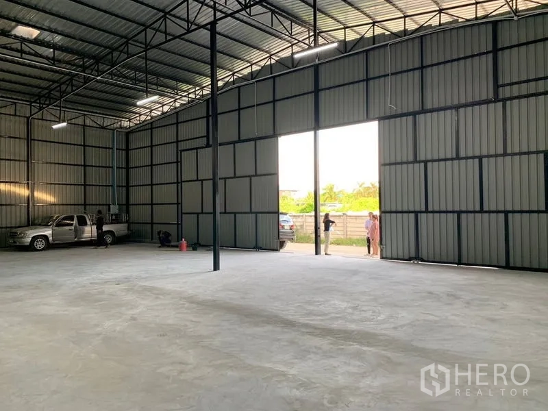 Warehouse for rent in Khan Na Yao, Bangkok - Interior view toward wide open sliding doors providing truck loading access and natural light.