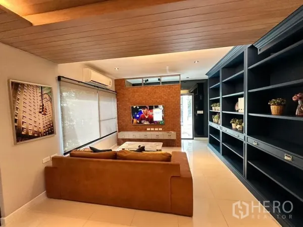 บ้าน ให้เช่าในBang Phli, Samut Prakan - มุมนั่งเล่นอบอุ่น ผนังอิฐตกแต่ง ชั้นหนังสือยาว เครื่องปรับอากาศ และพื้นกระเบื้อง