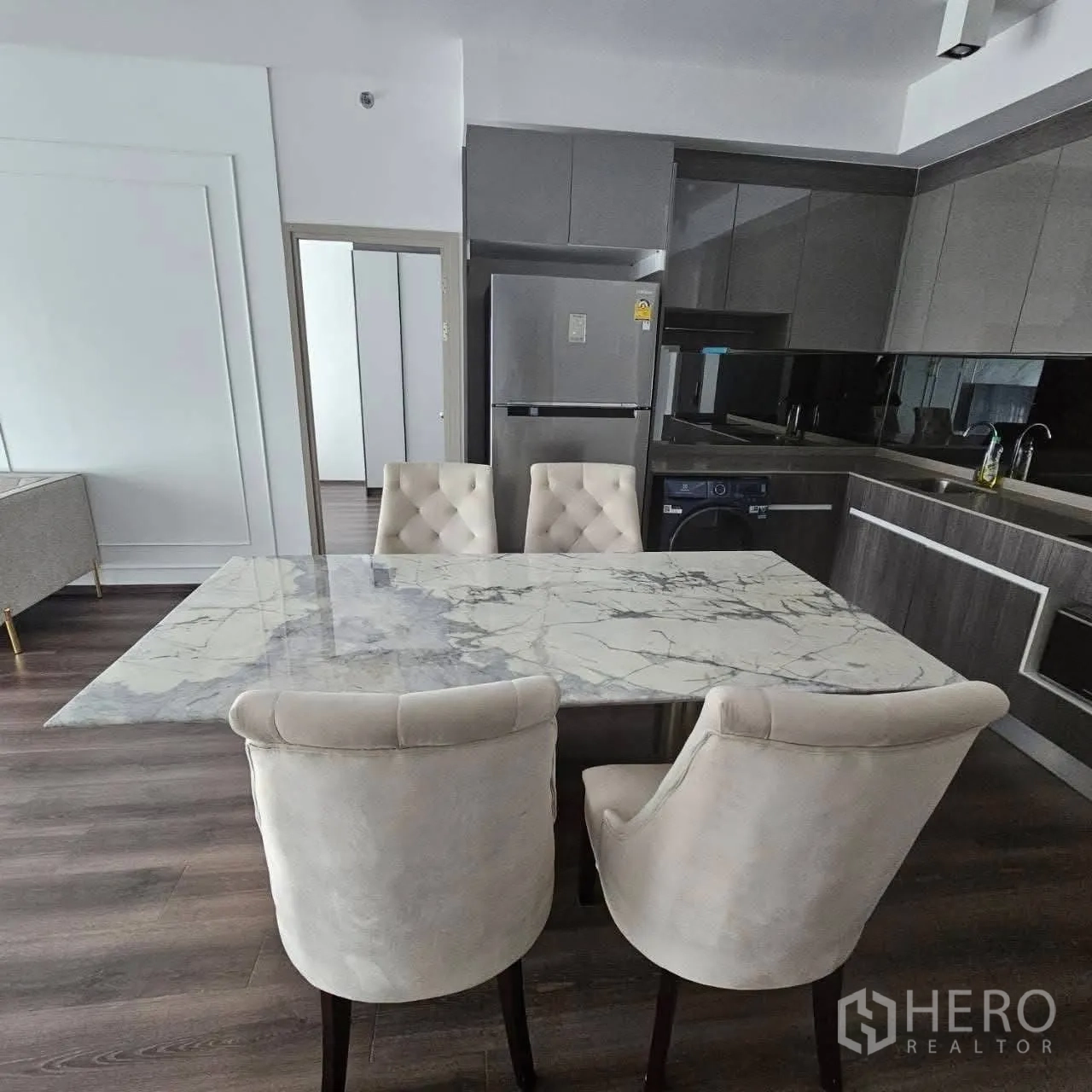 คอนโด for rent in Huai Khwang, Bangkok - ครัวและพื้นที่รับประทานอาหารพร้อมโต๊ะหินอ่อน เก้าอี้บุผ้า ตู้เย็น และบิลท์อิน