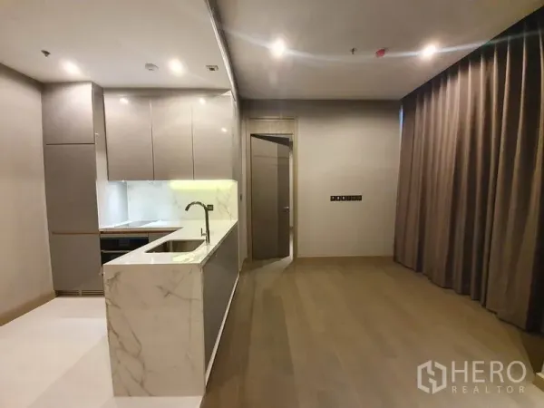 公寓 出租在Huai Khwang, Bangkok - 开放式起居与厨房，大理石岛台，内置家电与高柜，厚实窗帘。