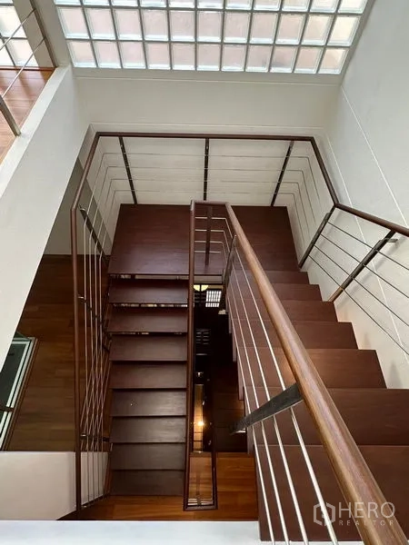 Townhouse for sale in Yan Nawa, Bangkok - Wood staircase with metal railing under skylit atrium spanning multiple floors