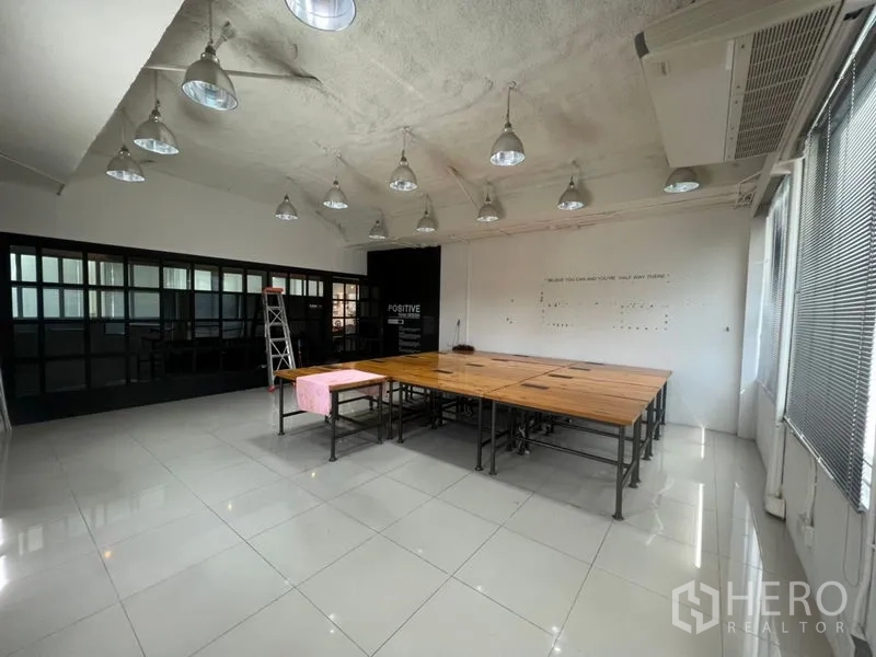 สำนักงาน ให้เช่าในKhlong Toei, Bangkok - ห้องทำงานกว้าง พื้นกระเบื้องเงา โต๊ะไม้รวมตรงกลาง เพดานสูงติดไฟแขวนสไตล์ลอฟต์