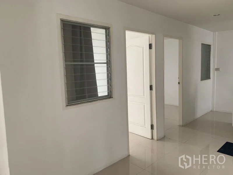 Townhouse for rent in Din Daeng, Bangkok - Upstairs corridor with louvered windows and white interior doors in a renovated townhouse.