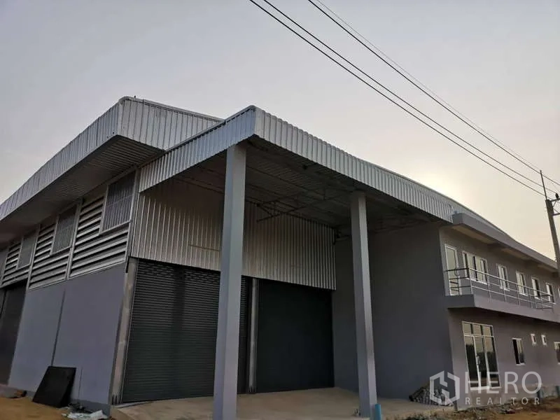 货栈 出租在Khlong Luang, Pathum Thani - 街景角度的仓库立面，带雨棚与双卷闸门。