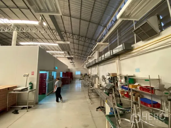 Warehouse for rent in Bueng Kum, Bangkok - Processing zone showing ventilation ducts, insulated doors and workbenches inside a large warehouse.