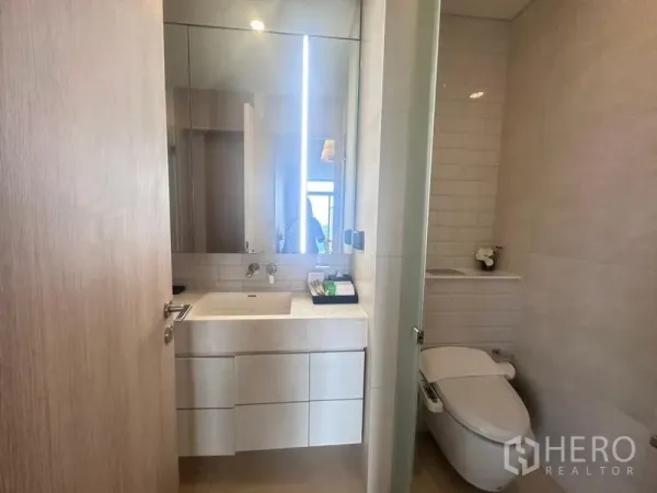 Condominium for rent - Modern bathroom with large mirrored vanity, smart toilet and neutral tiles.