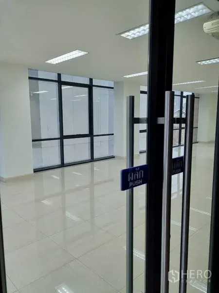 Office Space for rent in Bang Kho Laem, Bangkok - Glass entry door with push sign opening to a modern office featuring window walls and polished tile floors.