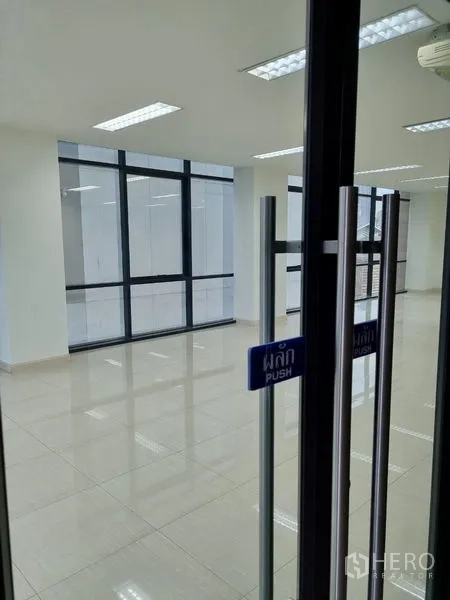 Office Space for rent in Bang Kho Laem, Bangkok - Glass entry door with push sign opening to a modern office featuring window walls and polished tile floors.