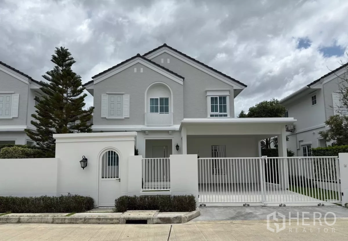 Detached House for rent or sale in Bang Phli, Samut Prakan - Two-storey white detached house with gated driveway and covered carport at Bangna KM.15 estate.