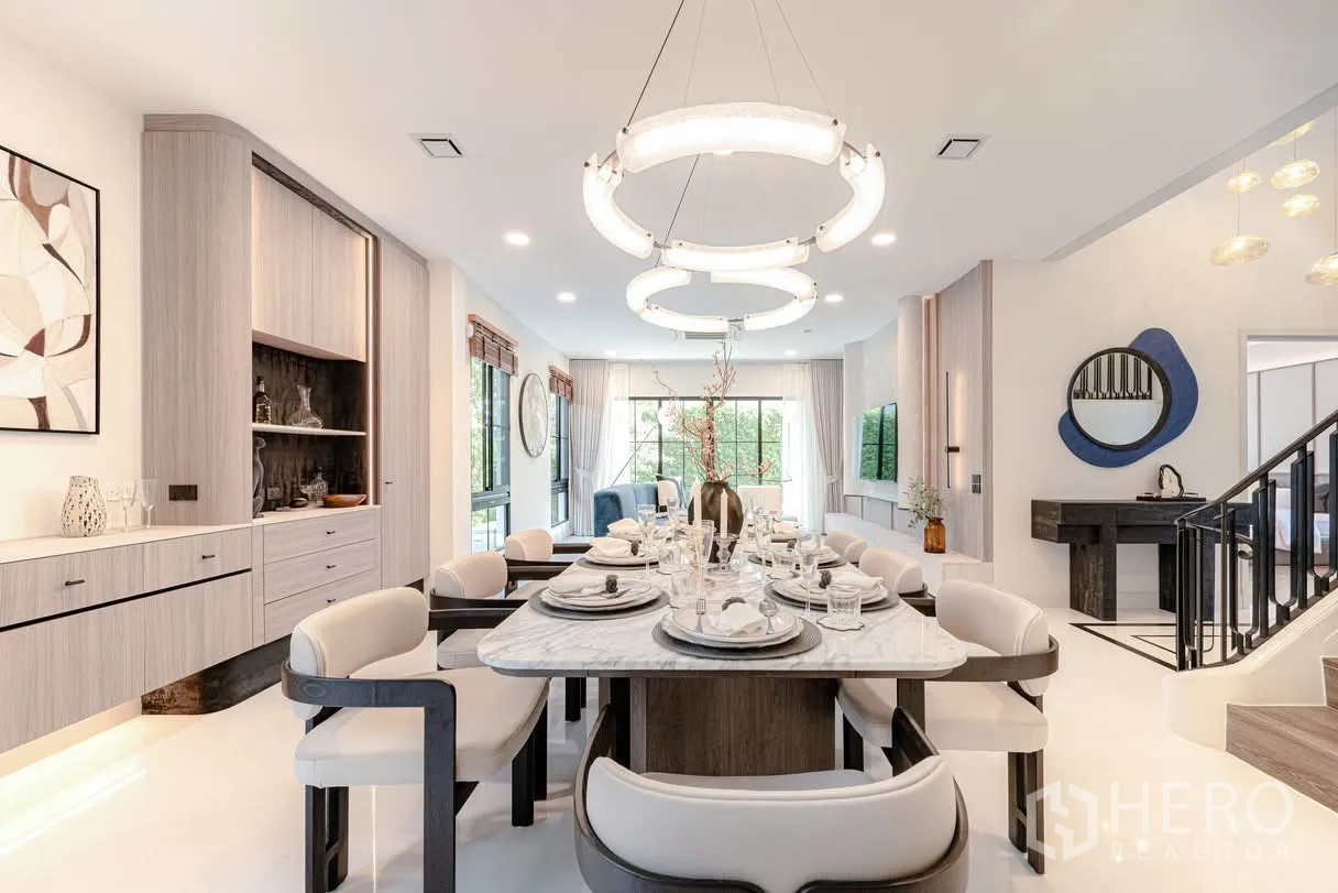 Detached House for rent in Saphan Sung, Bangkok - Open-plan dining area with designer lighting, built-in cabinetry, and view to living zone.
