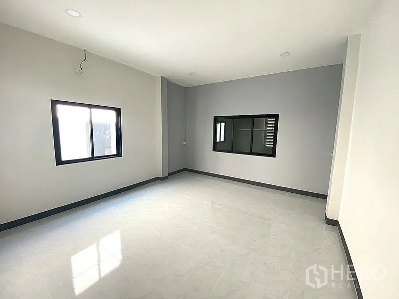 Warehouse for rent in Mueang Pathum Thani, Pathum Thani - Large multipurpose room with windows and light gray tiles, ready for office or living use.