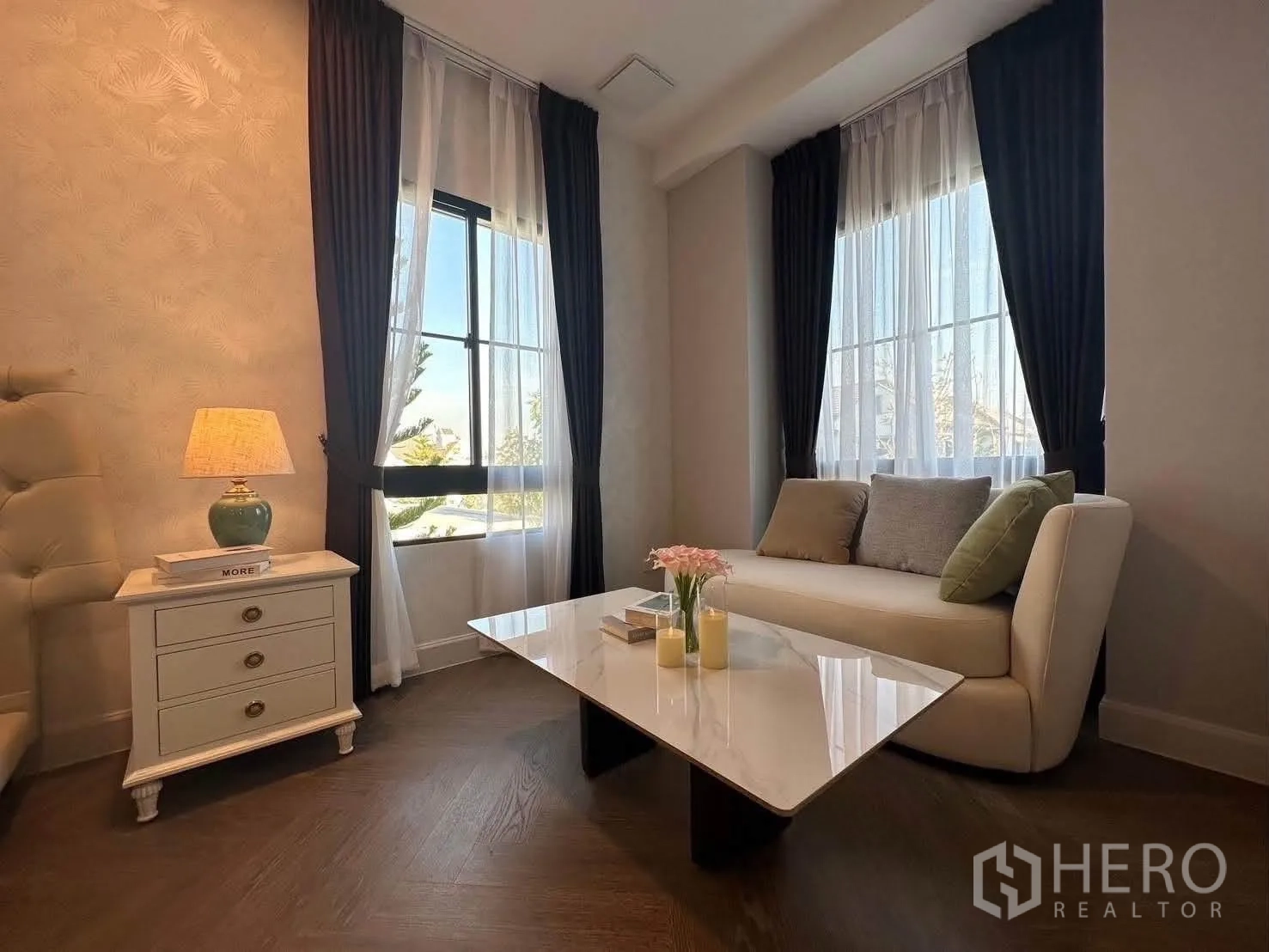 Detached House for rent in Saphan Sung, Bangkok - Cozy sitting nook with sofa and coffee table beside tall curtained windows.