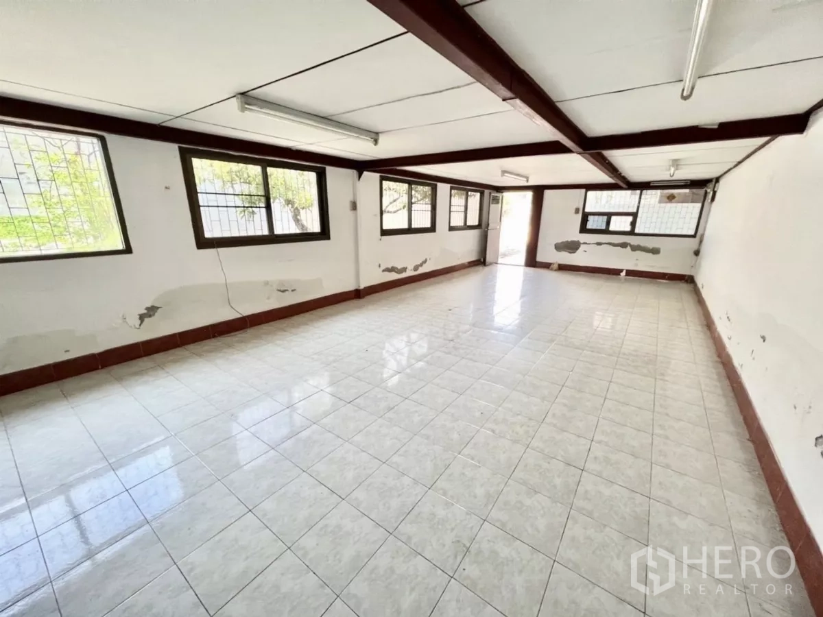 Warehouse for rent in Mueang Samut Prakan, Samut Prakan - Large tiled office room with multiple windows and fluorescent lighting.
