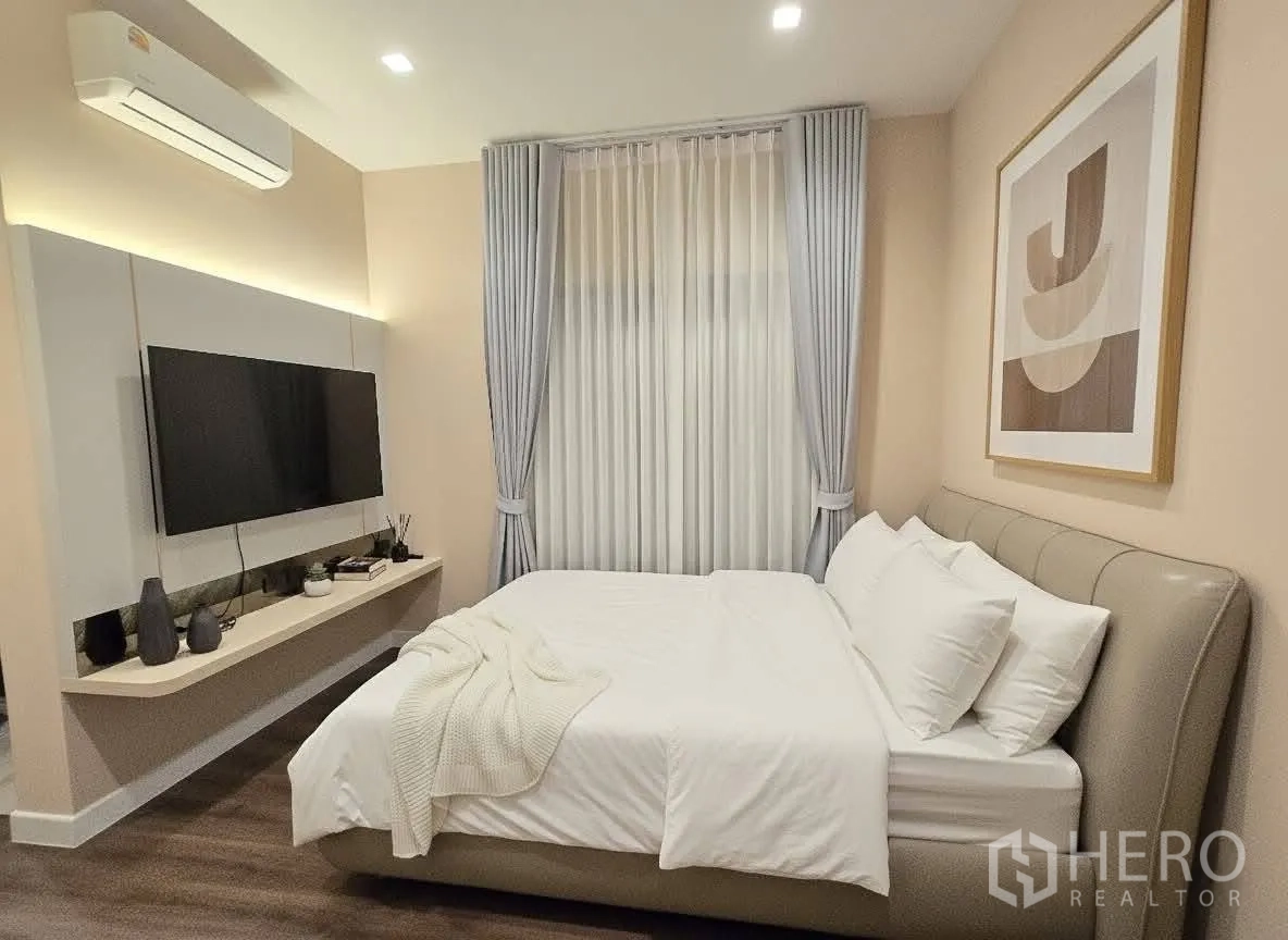 บ้าน for rent or sale in Bang Phli, Samut Prakan - ห้องนอนอบอุ่น เตียงบุผ้า ผนังทีวี และผ้าม่านสูงจรดเพดาน