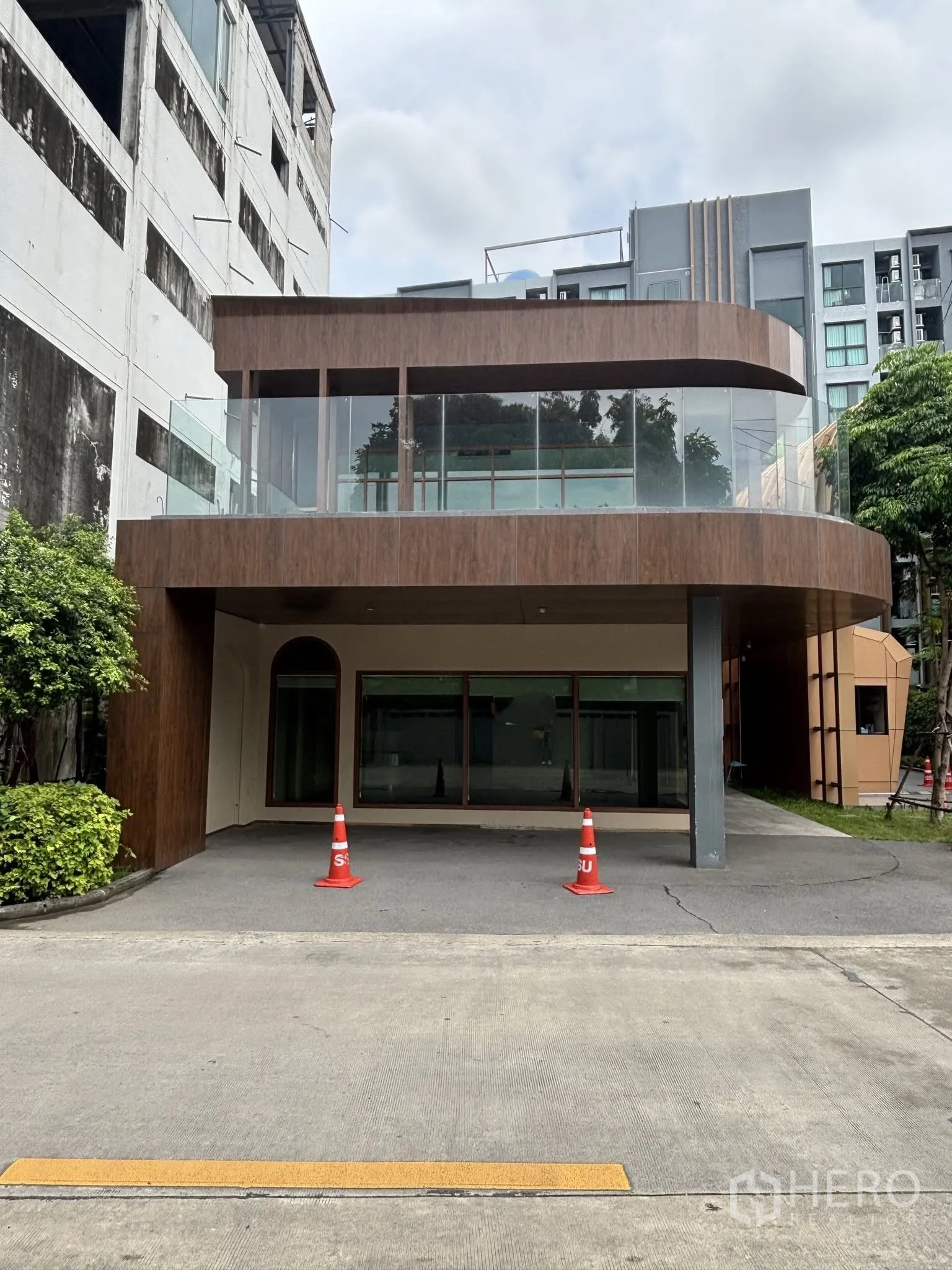 Retail Space for rent in Watthana, Bangkok - Contemporary two-storey retail building exterior with curved glass balcony and a covered forecourt.