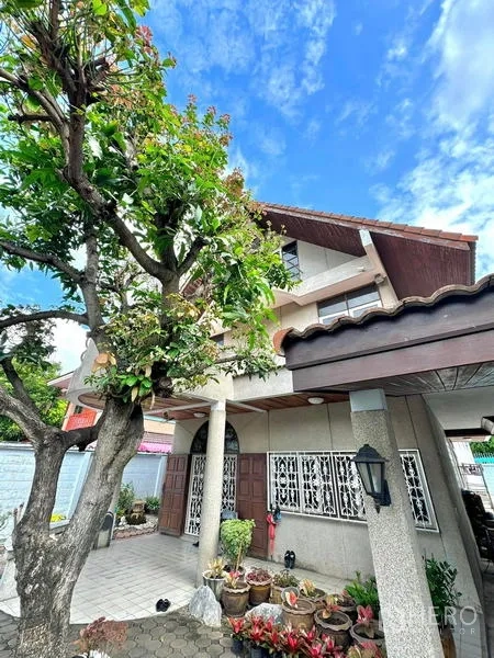 Detached House for sale in Yan Nawa, Bangkok - Front entrance with covered porch, arched double doors, tree and potted garden.