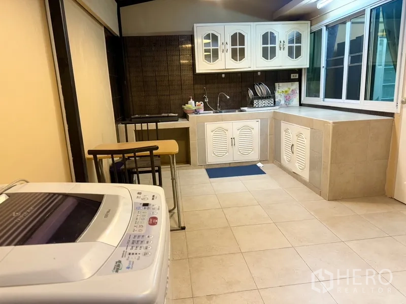 联排别墅 出租在Prawet, Bangkok - 封闭式泰式厨房，橱柜、水槽与洗衣机。