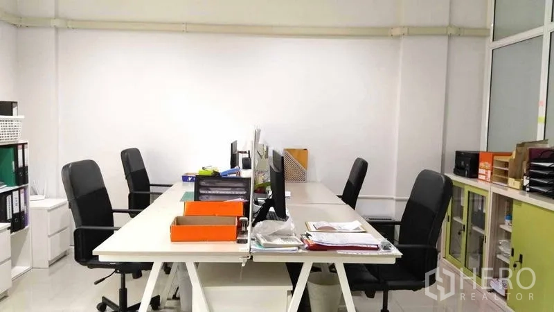 Home Office for rent - Open-plan workspace with long desks, office chairs and filing cabinets.