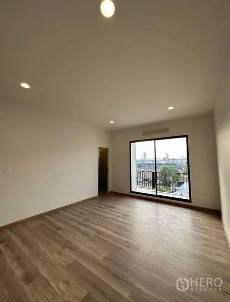 Townhouse for rent in Yan Nawa, Bangkok - Large bedroom with sliding glass doors opening to a balcony.