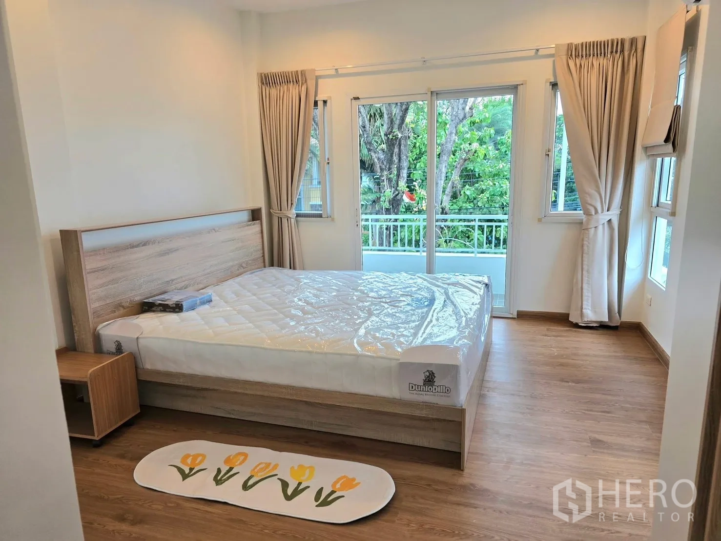 บ้านเดี่ยว for rent in Bang Phli, Samut Prakan - ห้องนอนสว่าง เตียงคู่ ประตูกระจกเปิดสู่ระเบียง พื้นไม้
