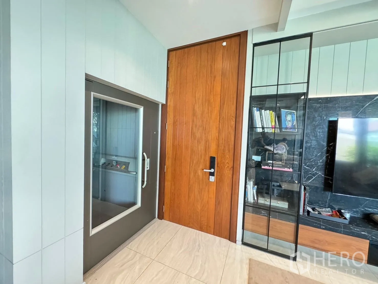 独立式住宅 出租或出售在Prawet, Bangkok - 入户旁的私人电梯，配高挑木门与陈列柜。