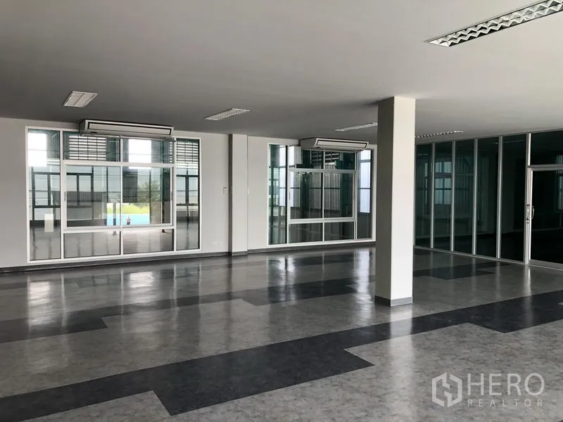Factory for rent or sale in Bang Phli, Samut Prakan - Large office area with windows on two sides and sliding glass doors.