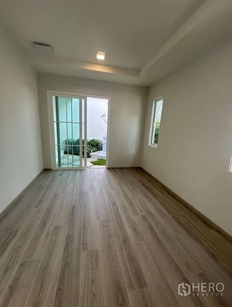 Detached House for rent - Ground-floor room with wood floors and a sliding glass door opening to the patio and garden.