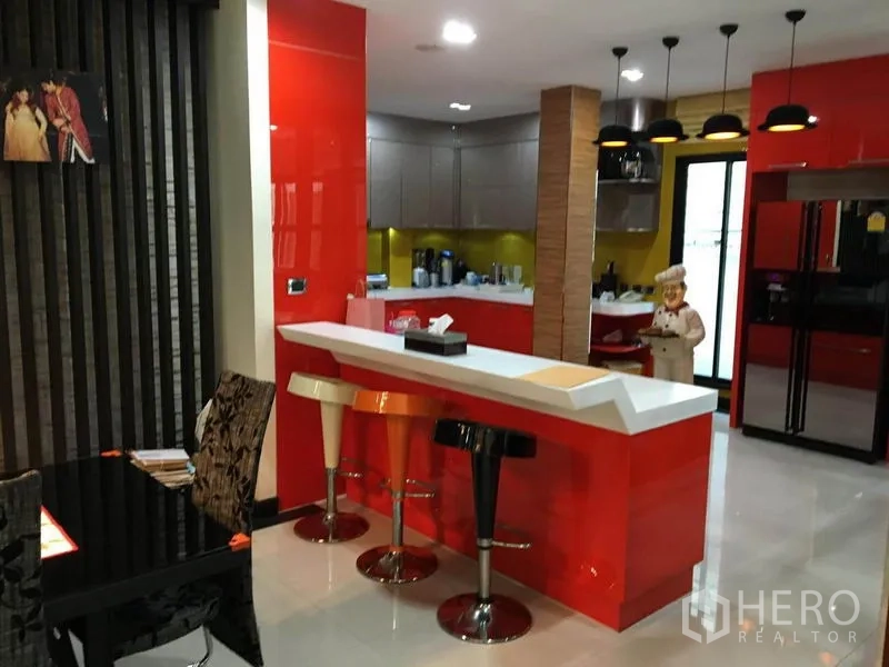 บ้าน ให้เช่าในKhlong Toei, Bangkok - ครัวสมัยใหม่ ตู้สีแดง เคาน์เตอร์บาร์พร้อมสตูล และไฟห้อย