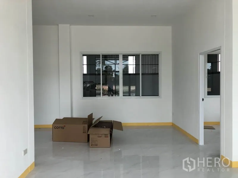 Factory for rent or sale in Sai Noi, Nonthaburi - Open-plan office room with a large window, white tiles and unpacked boxes on the floor.