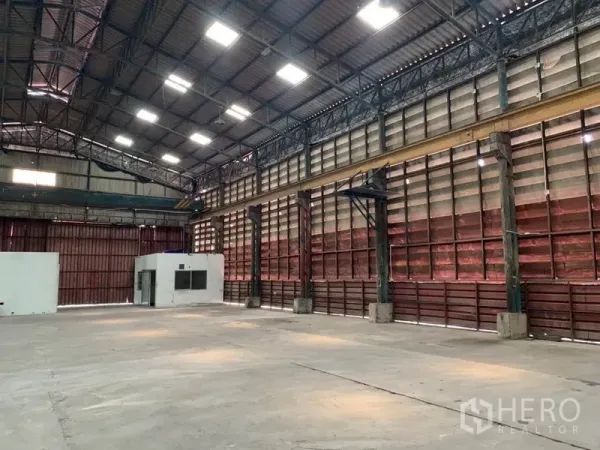 Warehouse for rent in Bang Kho Laem, Bangkok - Open-plan hall with clerestory windows and a small internal office unit at the side.