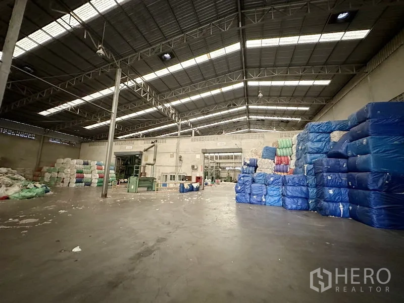 โรงงาน ให้เช่าในBang Bua Thong, Nonthaburi - โซนผลิตและจัดเก็บ ใต้โครงหลังคาเหล็ก พร้อมกองบรรจุภัณฑ์ห่อพลาสติก