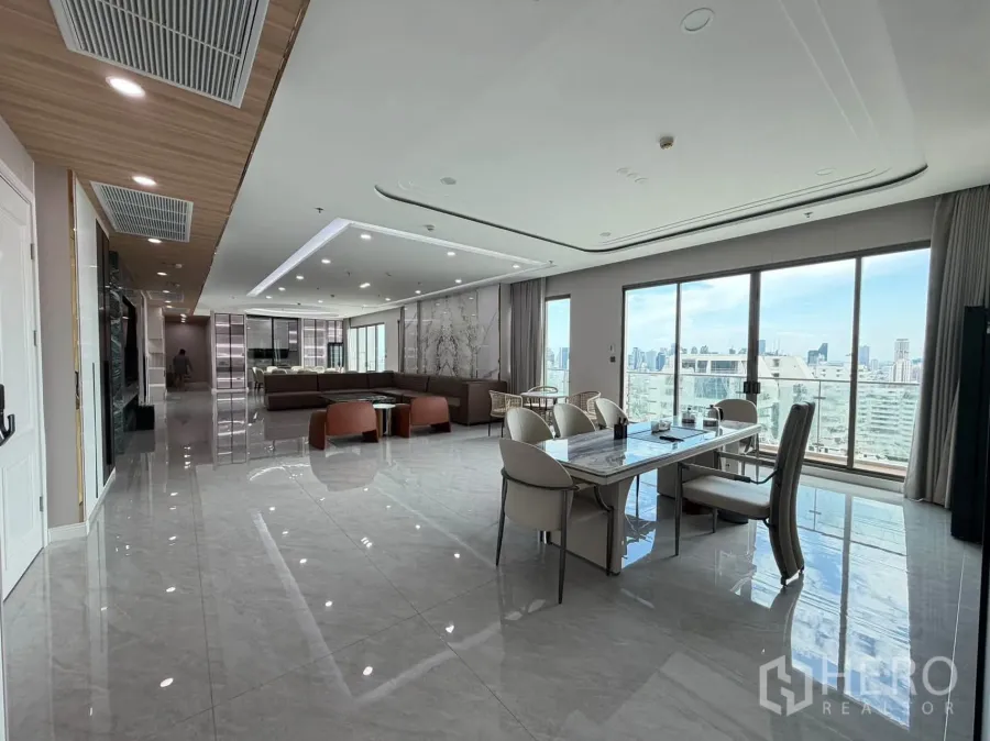 Condominium for sale in Watthana, Bangkok - Open living space with marble-look floors, dining set, and large windows.
