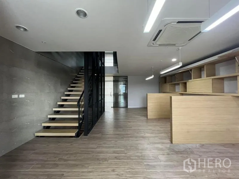 带办公室的家 出租在Bueng Kum, Bangkok - 开放办公楼层，楼梯与整面内置书架。