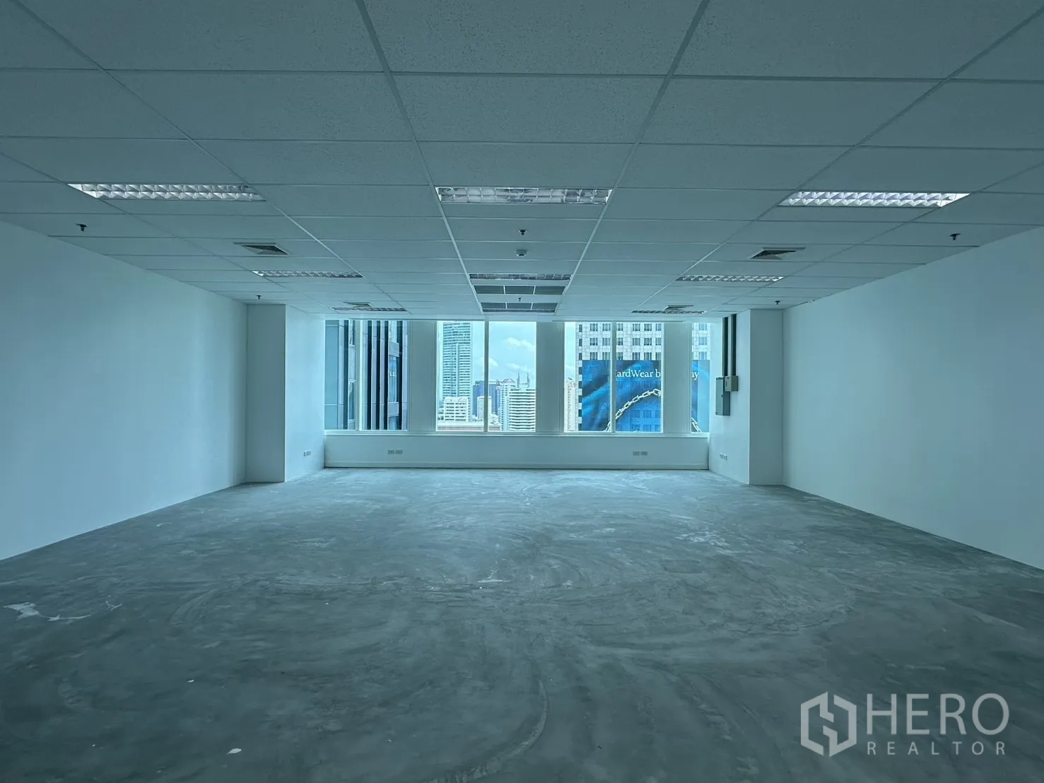 Office Space for rent in Watthana, Bangkok - Wide office interior facing windows with skyline backdrop and grid ceiling.