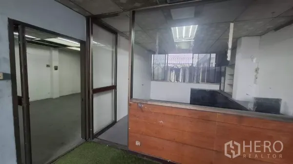 店屋 出租在Watthana, Bangkok - 玻璃分隔的办公室区域，带木质接待台。