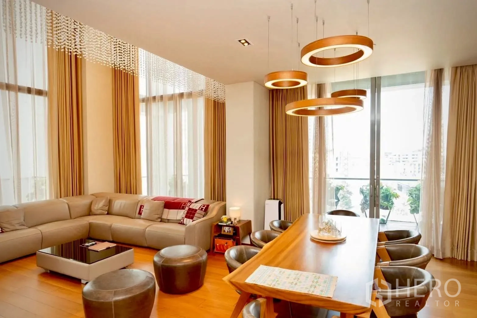 公寓 for sale in Sathon, Bangkok - 客餐厅一体空间，环形吊灯与阳台推门相连。