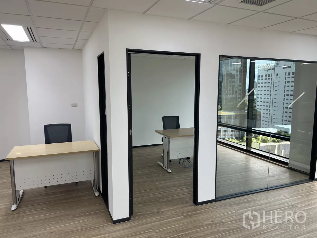 Office Space for rent - Two private offices with glass partitions and desks, offering city views through large windows.