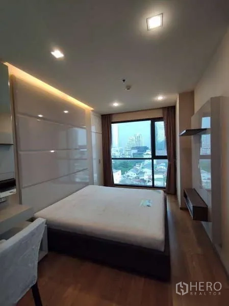 Condominium for rent in Bang Rak, Bangkok - Daylit bedroom with built-in cabinetry and city skyline view.