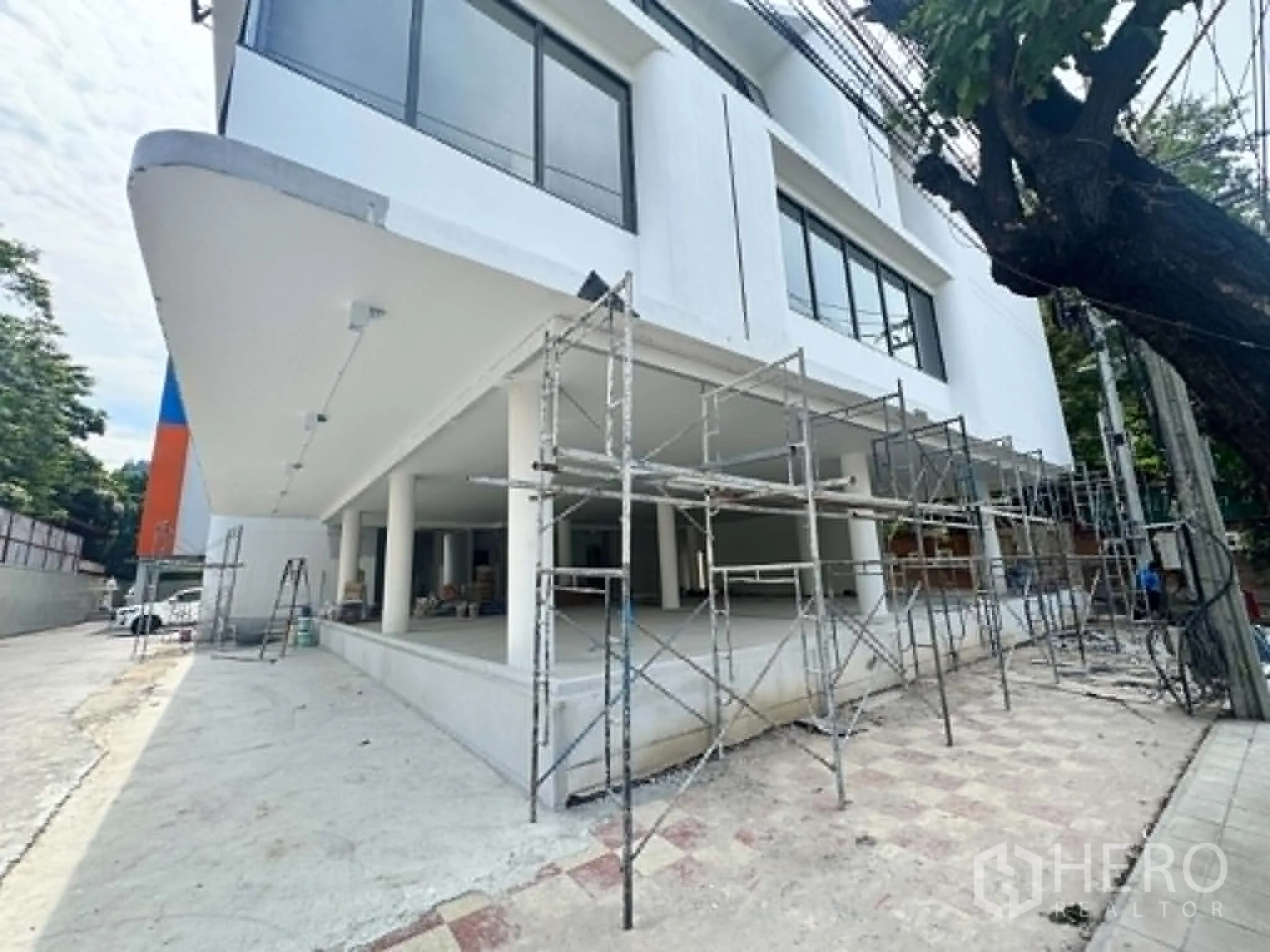 พื้นที่ขายของ for rent in Watthana, Bangkok - อาคารพาณิชย์สีขาวด้านหน้า มีนั่งร้านและชั้นล่างเปิดโล่ง