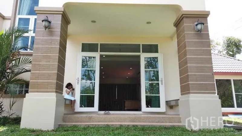 独立式住宅 出租或出售在Pak Kret, Nonthaburi - 房屋前门廊，双扇玻璃门、台阶与草坪。