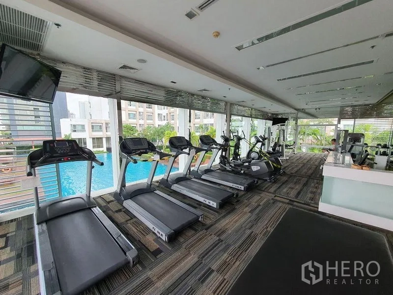 Condominium for sale - Condominium fitness center with treadmills and cardio machines overlooking the outdoor swimming pool.