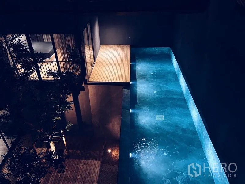 บ้าน ให้เช่าหรือขายในBangkok - มุมมองยามค่ำของสระว่ายน้ำส่วนตัวยาวพร้อมดาดไม้