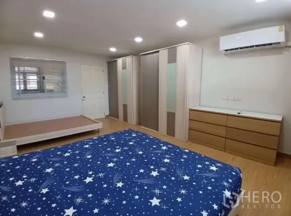 Shophouse for rent in Phra Khanong, Bangkok - Bright bedroom featuring air conditioner, built-in wardrobes, dresser and a star-pattern bed.