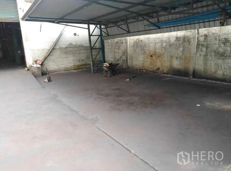 货栈 出租在Prawet, Bangkok - 带金属雨棚的装卸区，宽阔混凝土场地可停放卡车。