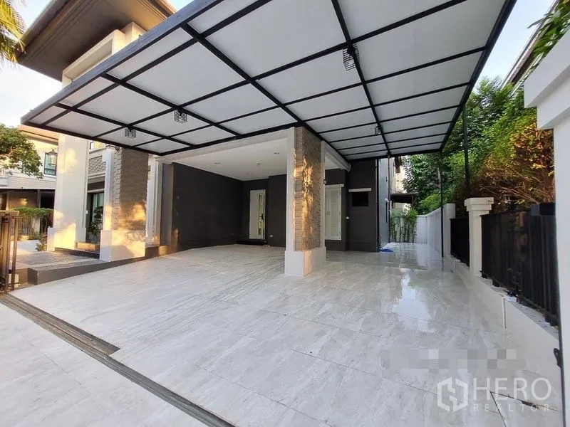 Detached House for rent in Bang Khae, Bangkok - Wide covered carport with tiled driveway and modern facade at the front of the house.