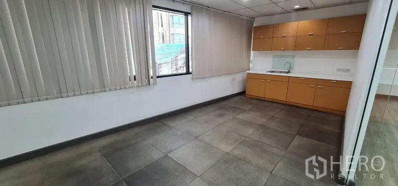 办公空间 出租在Watthana, Bangkok - 茶水间，带内置柜、洗手池、瓷砖地面与百叶窗。