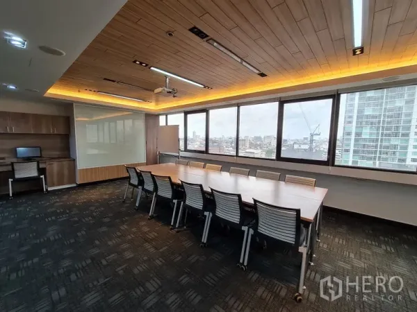 Office Space for rent in Bang Rak, Bangkok - Conference room with panoramic windows, city views, and built-in cabinetry beneath feature lighting.