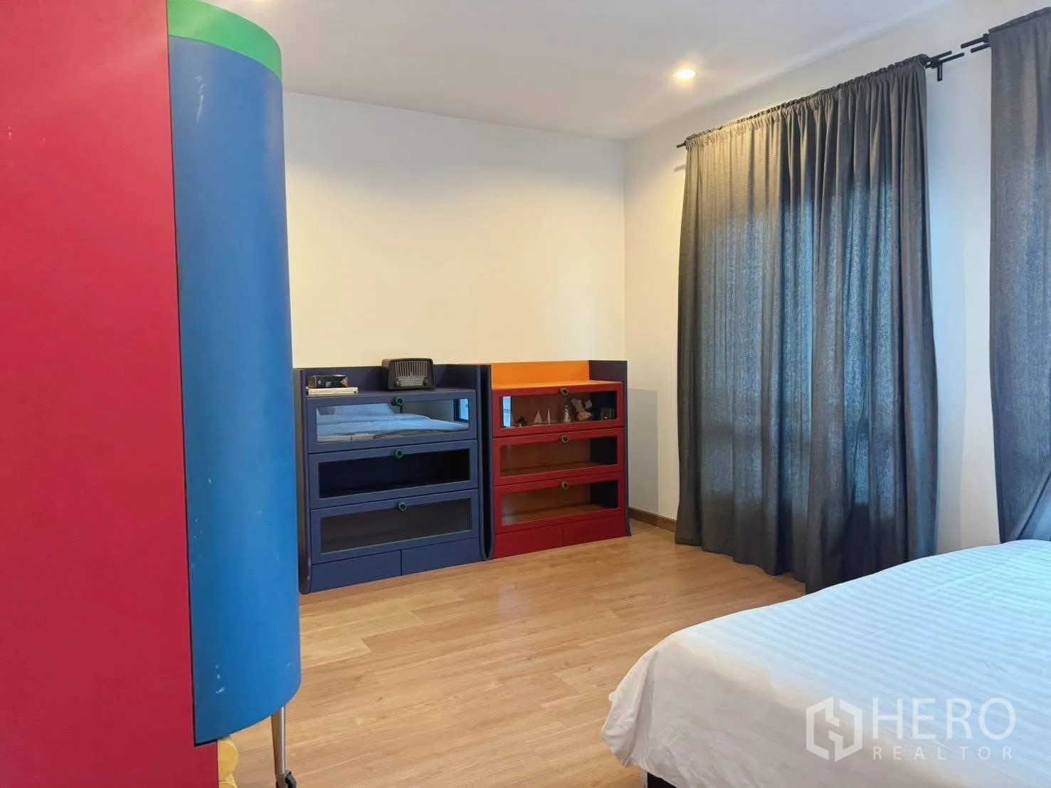 บ้านเดี่ยว for rent or sale in Suan Luang, Bangkok - ห้องนอนมีชั้นเก็บของสีสัน เตียง และผ้าม่านสีเข้ม