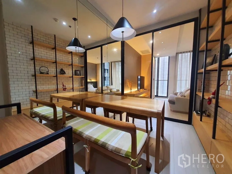 公寓 出租在Pathum Wan, Bangkok - 餐厅配木质餐桌长凳、吊灯、镜面墙与开放置物架。