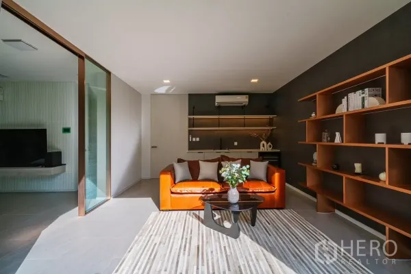 Detached House for rent or sale in Saphan Sung, Bangkok - Cozy family room with orange leather sofa, built-in shelves and large windows.